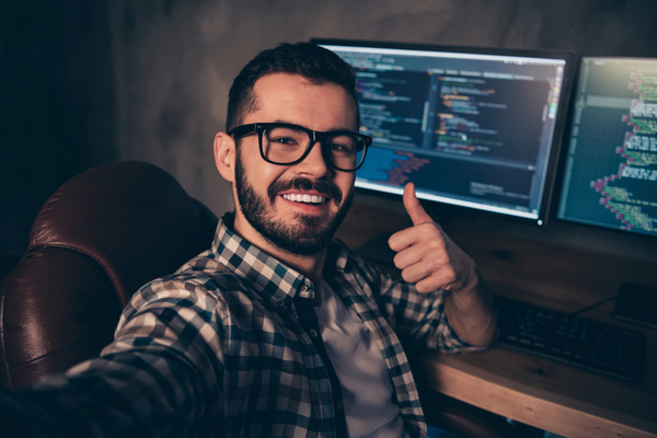 guy-smiling-in-front-of-the-computer-giving-a-thumbs-up