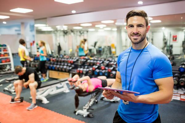 gym-instructor-in-blue-shirt-holding-a-checklist-in the gym