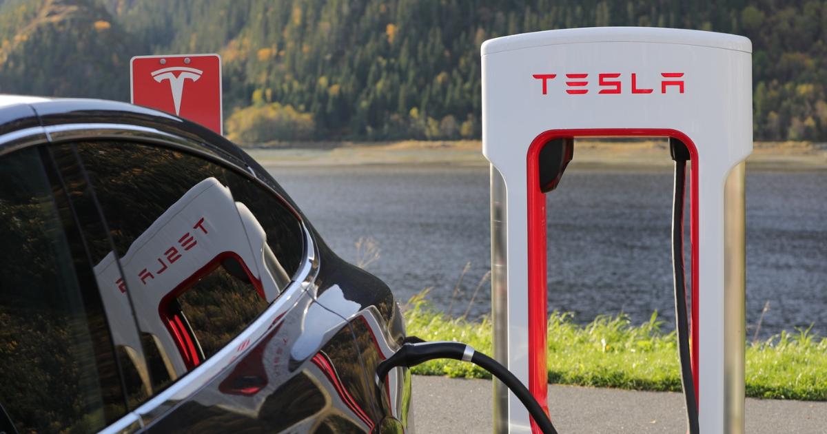 Close-up image of a Tesla car connected to a Tesla charging station, highlighting the vehicle being charged.