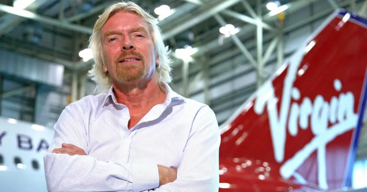 Close up of mentors; Richard Branson standing in front of a virgin airlines plane.